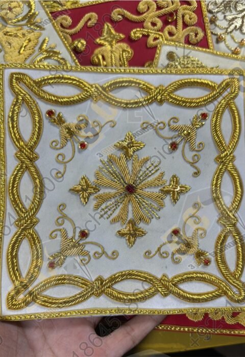 Hand embroidered goldwork badge with decorative border and cross motif